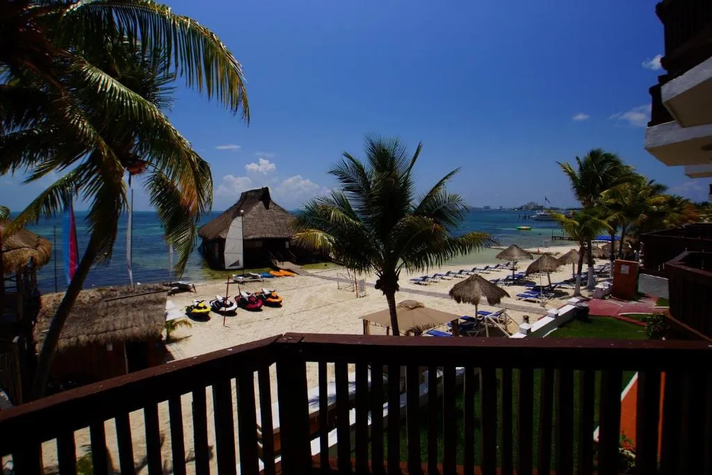 Alberca al aire libre con camastros y vista al Mar Caribe en Imperial Las Perlas Cancún